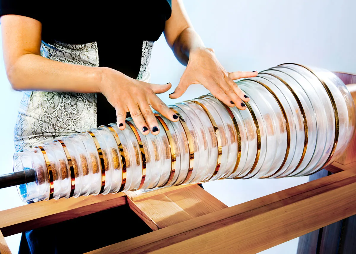 Zwei Hände spielen auf den sich drehenden Glasschalen einer Glasharmonika